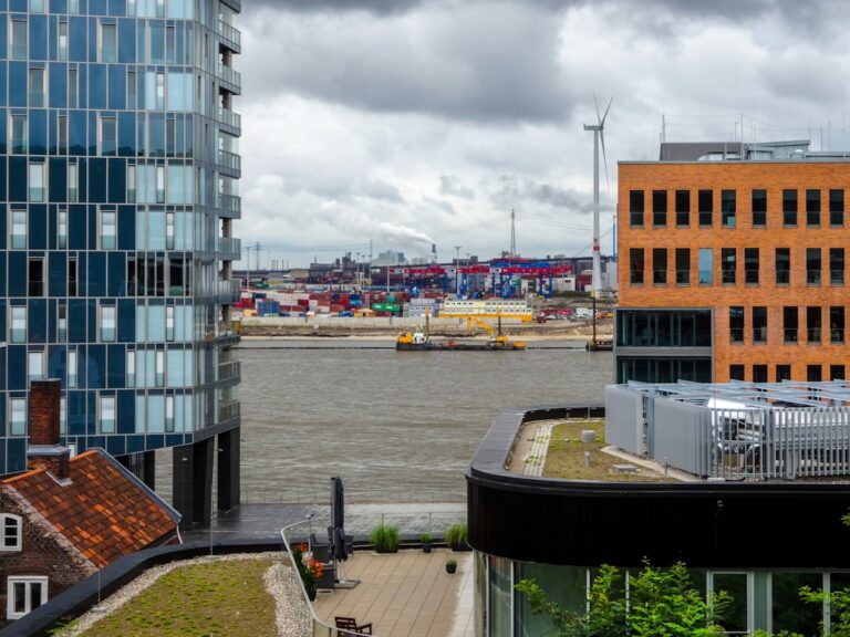 Edificios Modernos Tem Vista Para Um Porto Movimentado Com Guindastes E Navios wZViBqORqPE