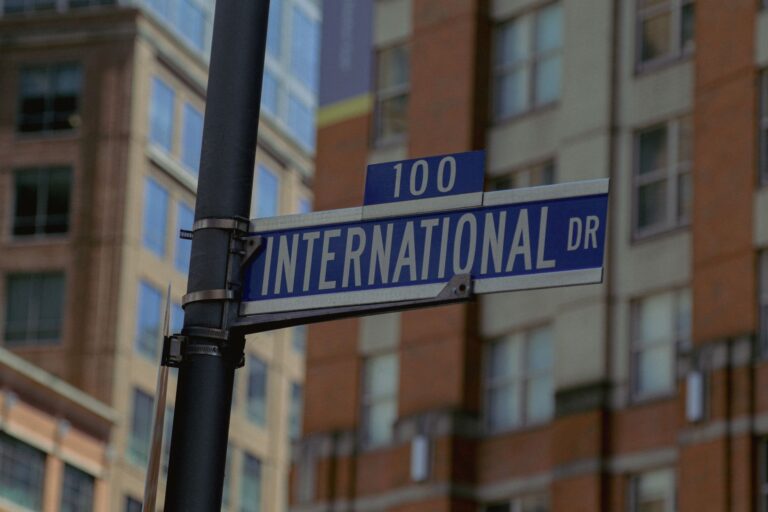 Close-up of 100 International Dr street sign with urban backdrop in Baltimore, Maryland.