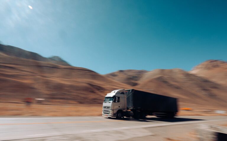 Dynamic shot of a cargo truck speeding along a mountain road in Mendoza Province, Argentina.