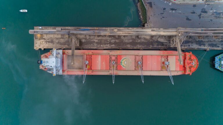 Drone shot of cargo ship docked at São Francisco do Sul harbor, showcasing maritime activity from above.