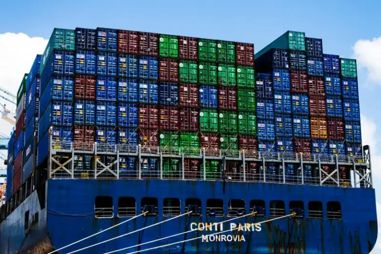 Stacked cargo containers on a massive ship at the harbor, symbolizing global trade.