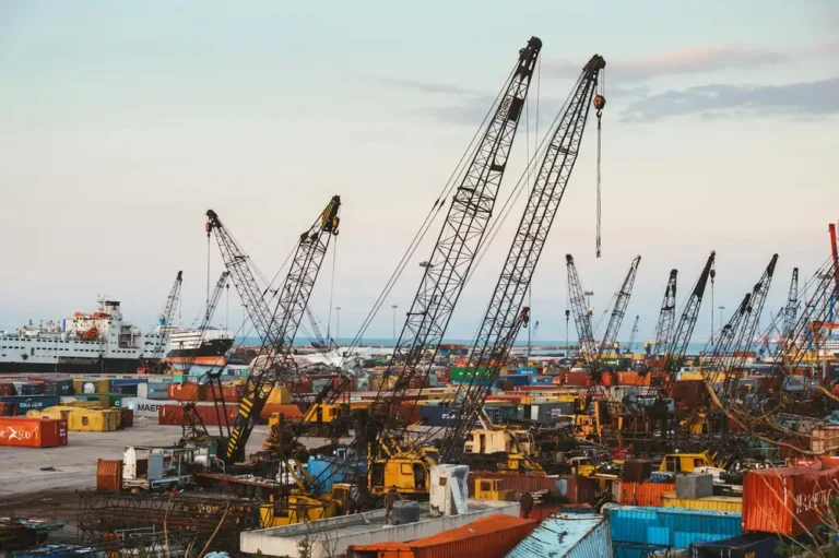 A bustling industrial port in Beirut with cranes and cargo containers.