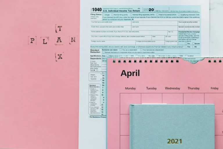 Tax-related items on a pink background, including forms and a calendar.