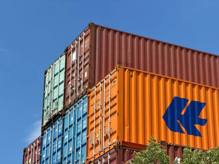 Colorful shipping containers stacked in an outdoor storage area in Germany.