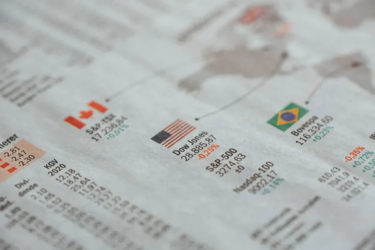 Detailed close-up of a newspaper displaying global financial market statistics and country flags.